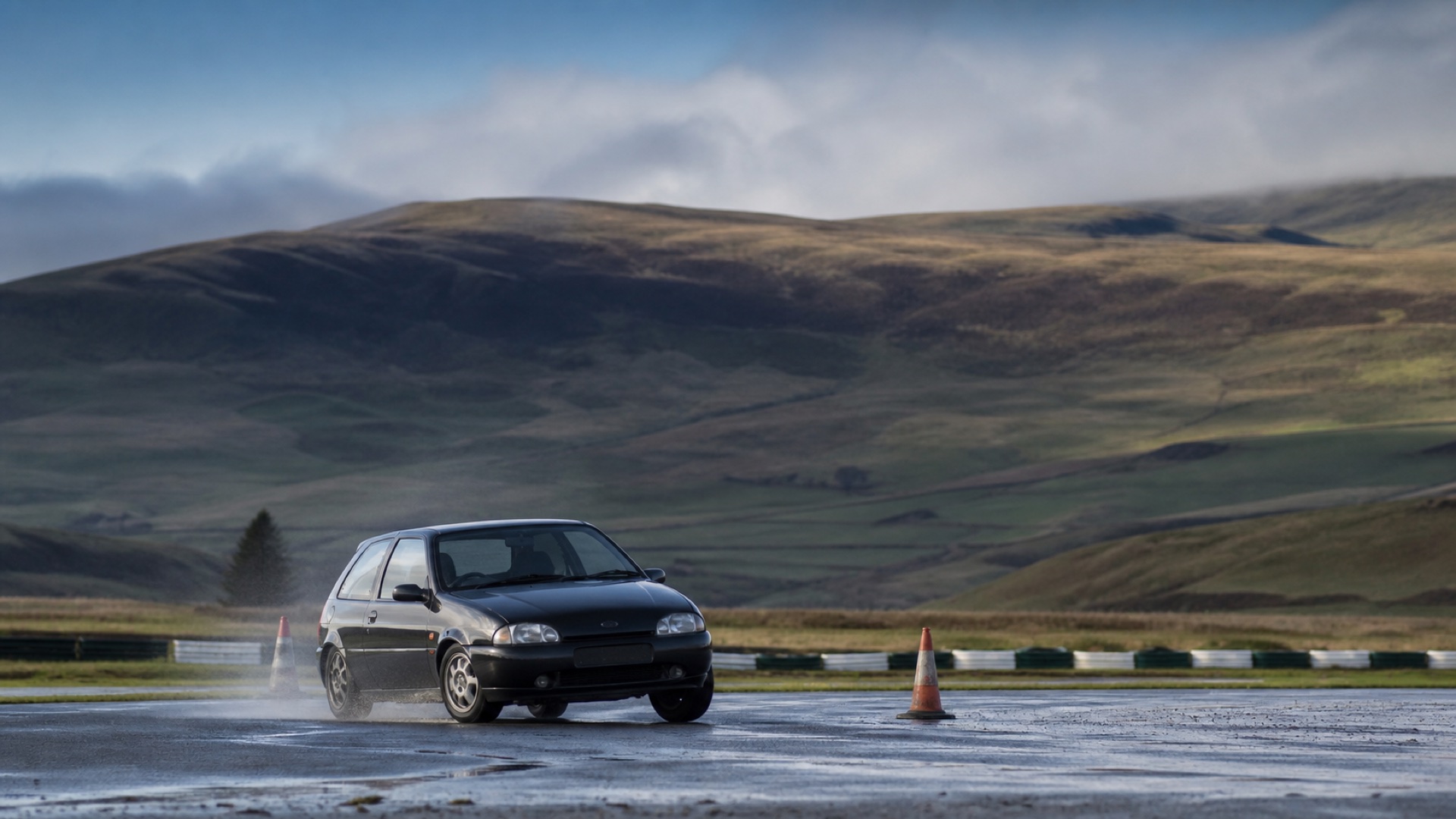 Competition car navigating an autotest course in a Welsh valley